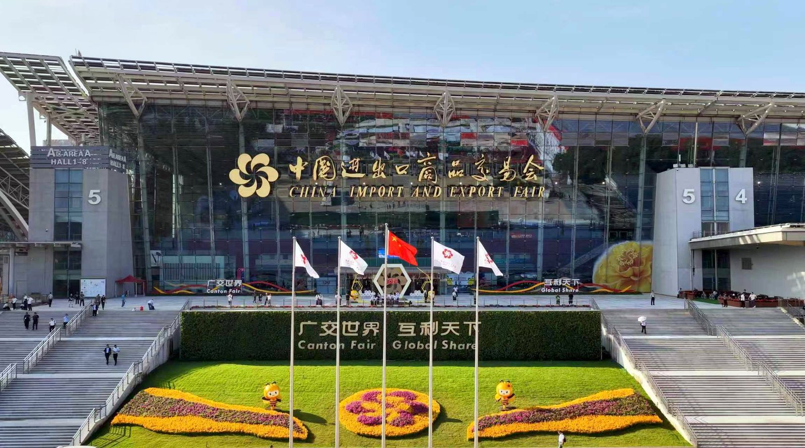 Entrada principal del recinto de la Feria de Cantón en Guangzhou, con banderas y jardines